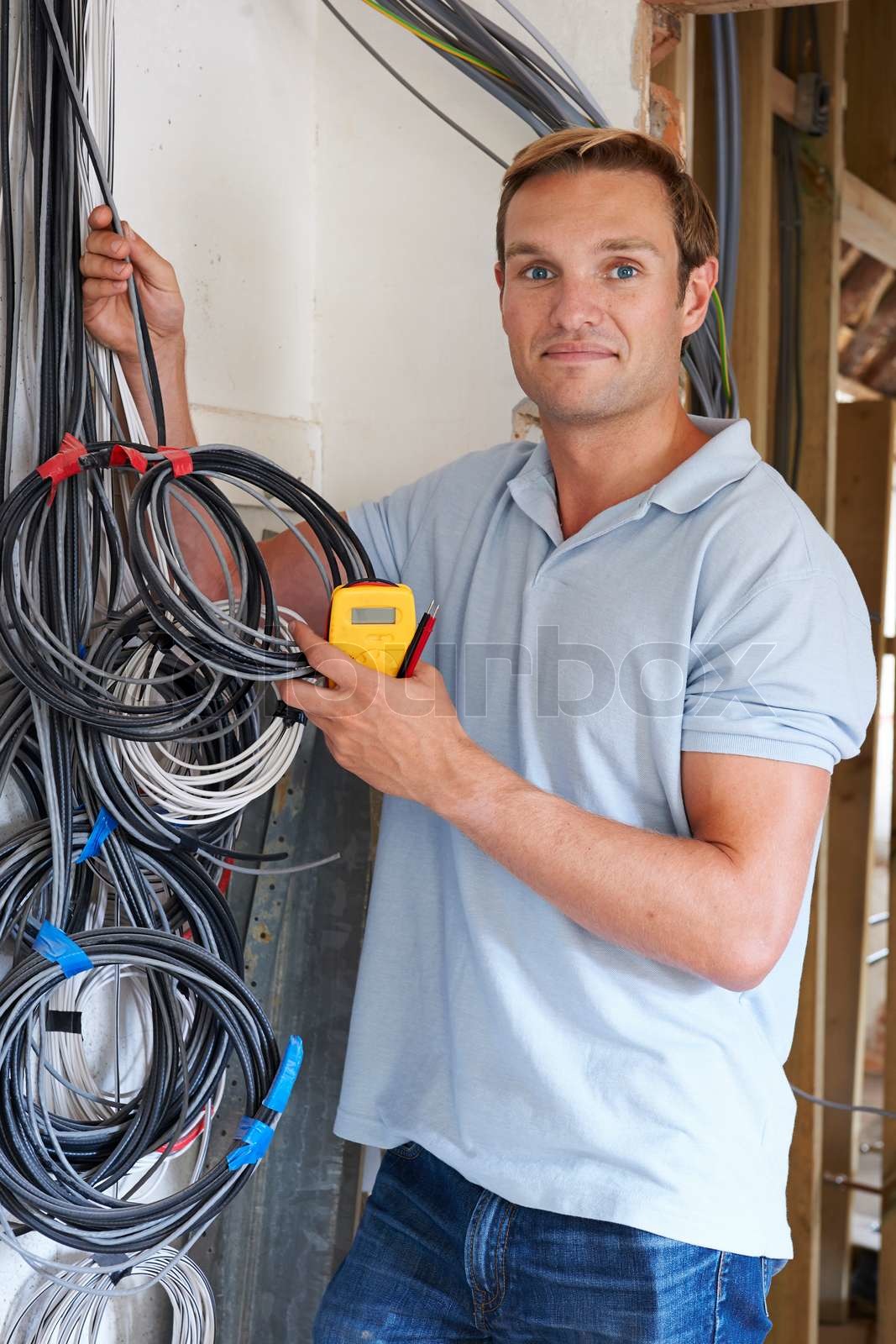Electrician Fitting Wiring On Construction Site Stock image