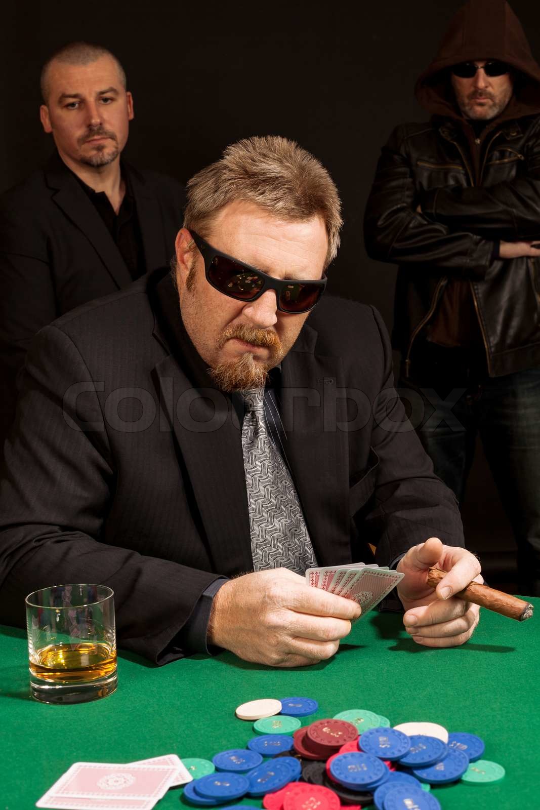 Photo of a man playing poker while wearing sunglasses and sm Colourbox