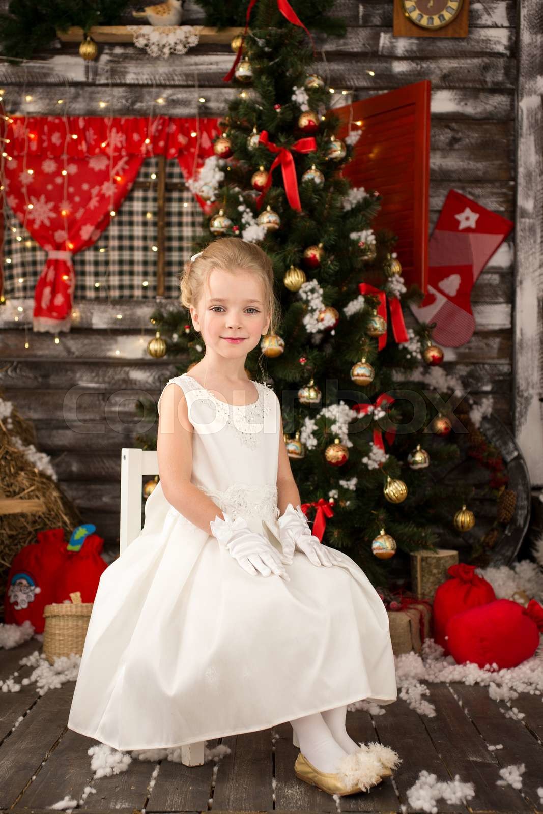 Cute Young beautiful girl in white Christmas dress is sittin Colourbox