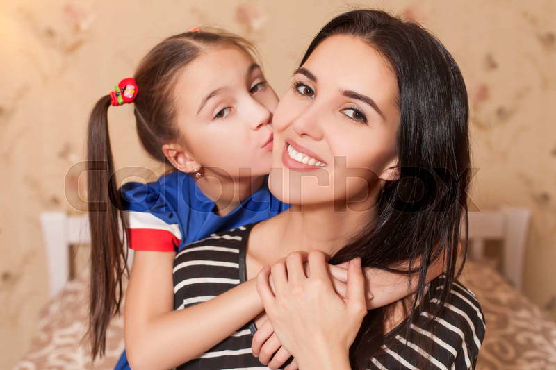 little girls kissing each other Little girl kissing her happy mother. | Colourbox