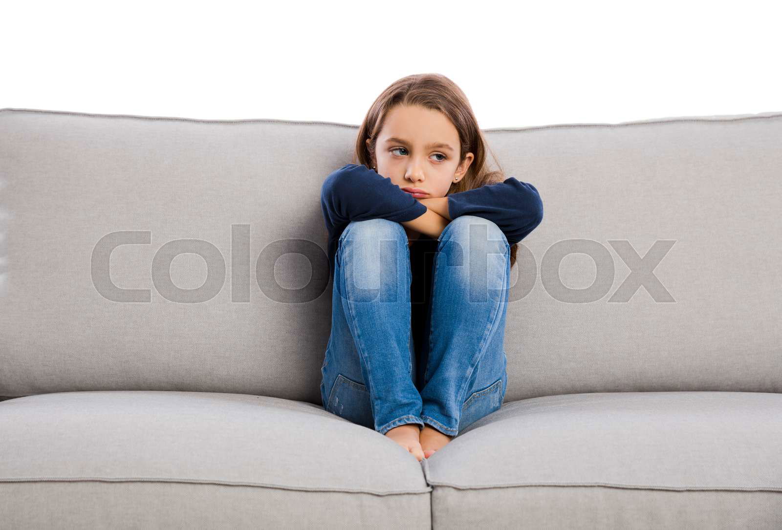 Little girl sitting on a couch and upset with something Colourbox