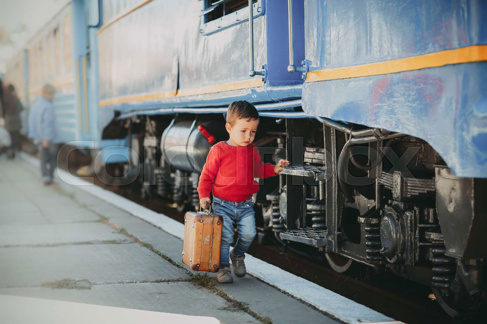 Adorable little kid boy dressed in red sweater on a railway Colourbox