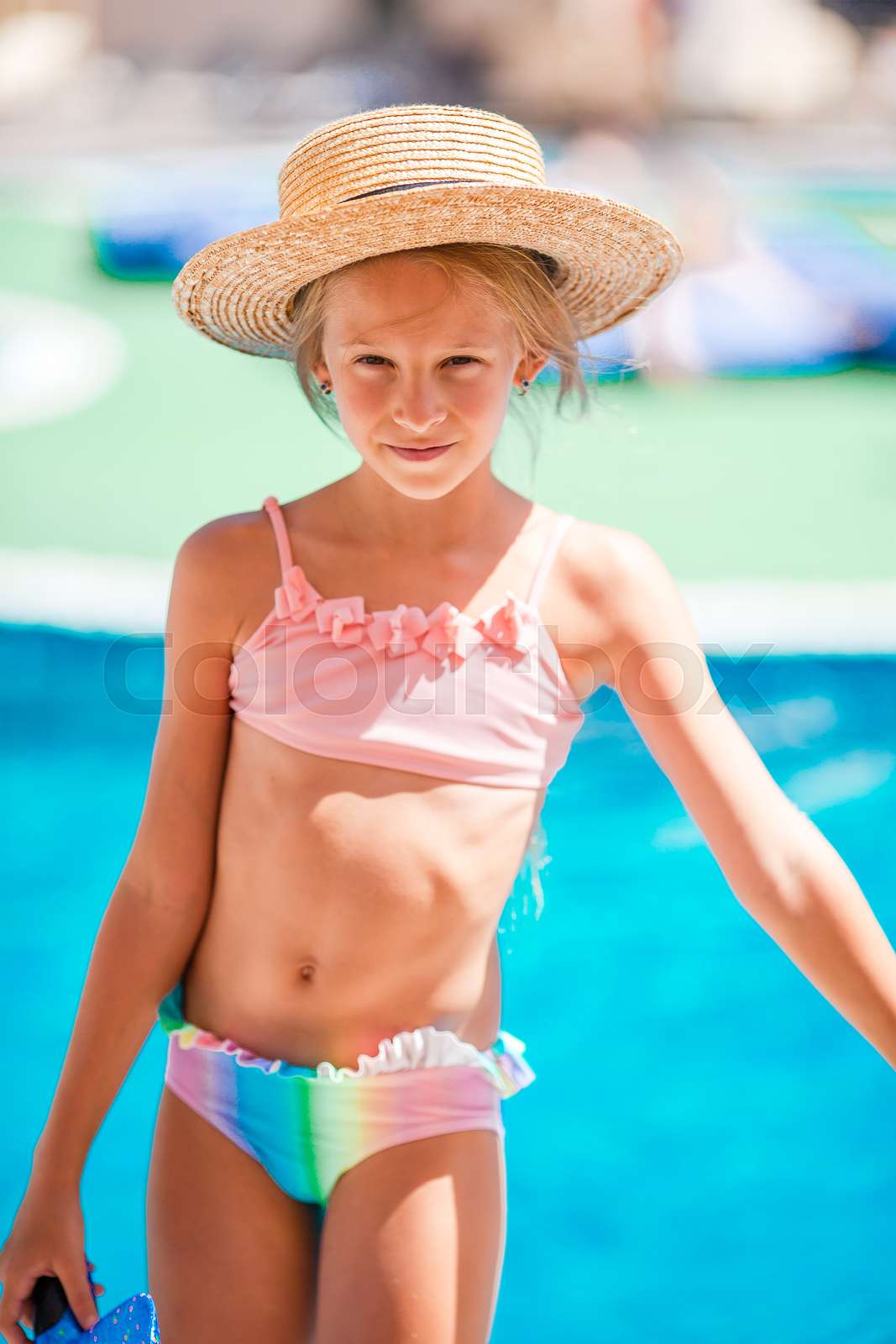 Cute little girl swims in outdoor swimming pool. Summer outd Colourbox