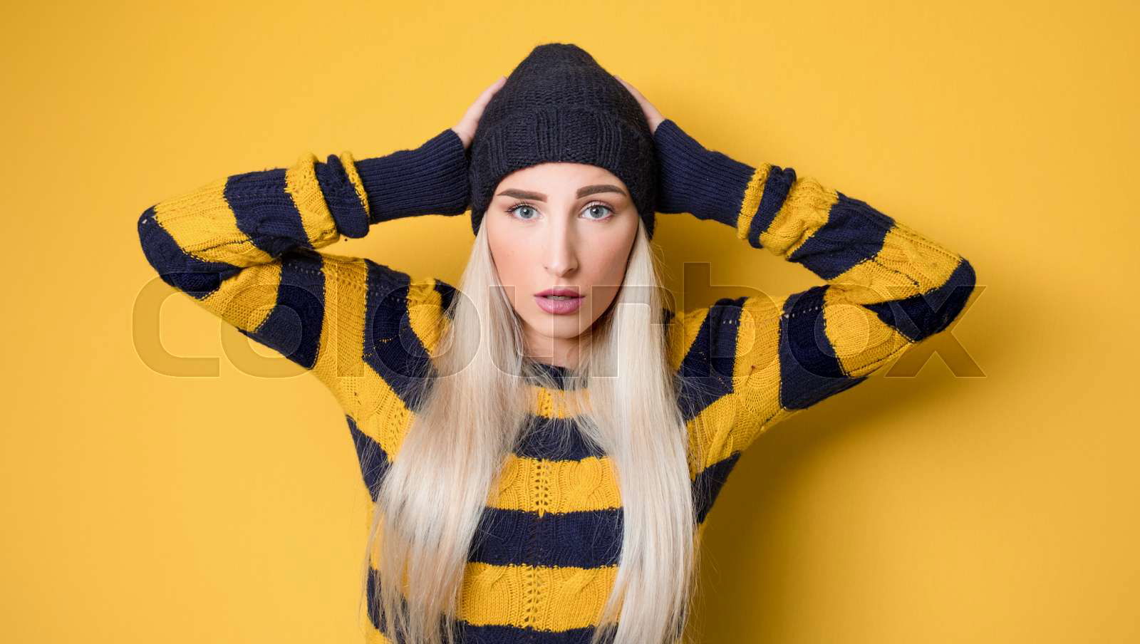 Panicking young woman stare to you model wearing woolen cap Colourbox