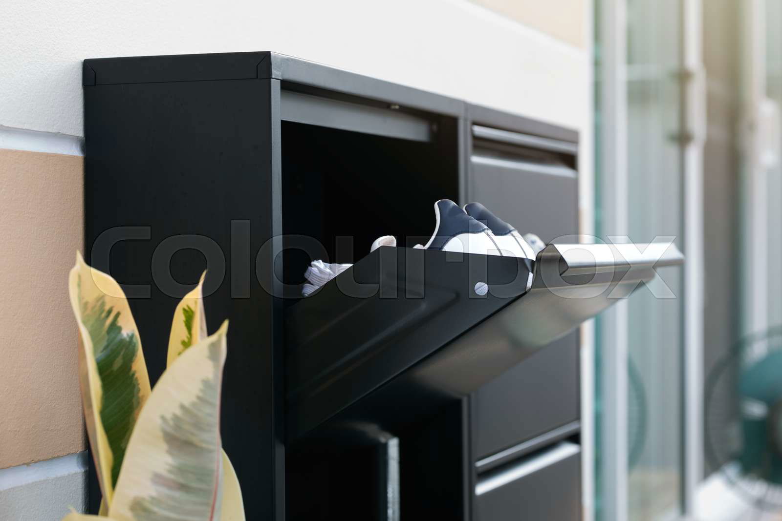 Metal shoe cabinet with lock. Black shoes storage front of t Colourbox