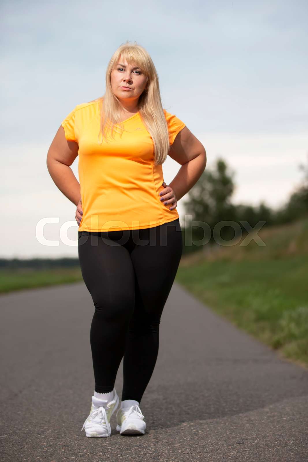 Portrait of a European middle aged woman in a tracksuit pos Colourbox