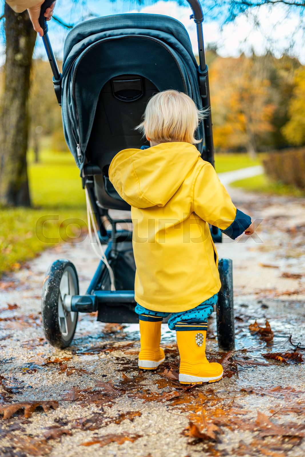 Sun always shines after the rain. Small blond infant boy wea Colourbox