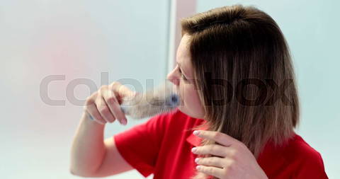 A young woman is shocked by hair loss at a comb, a close-up. |            Colourbox        