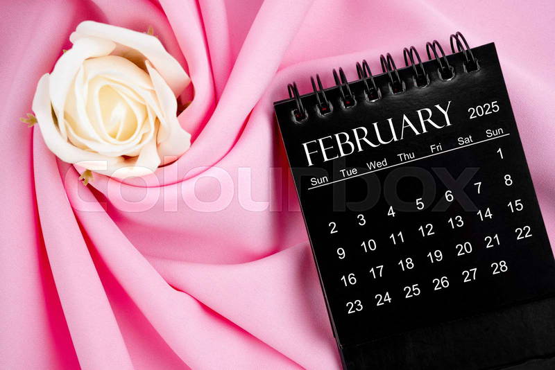 Desk calendar for february 2025. desktop calendar on a black | colourbox