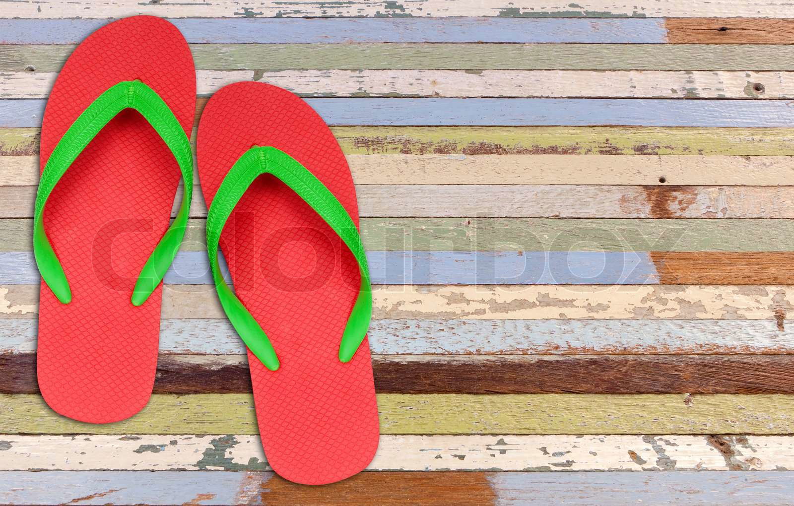 Red and green flip flop sandals on old painting wood Colourbox